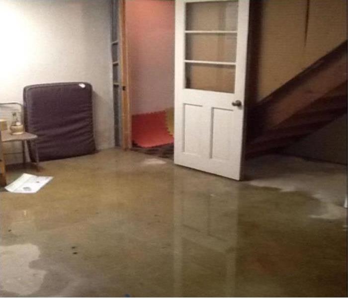 water on floor of a room, opened door nearby