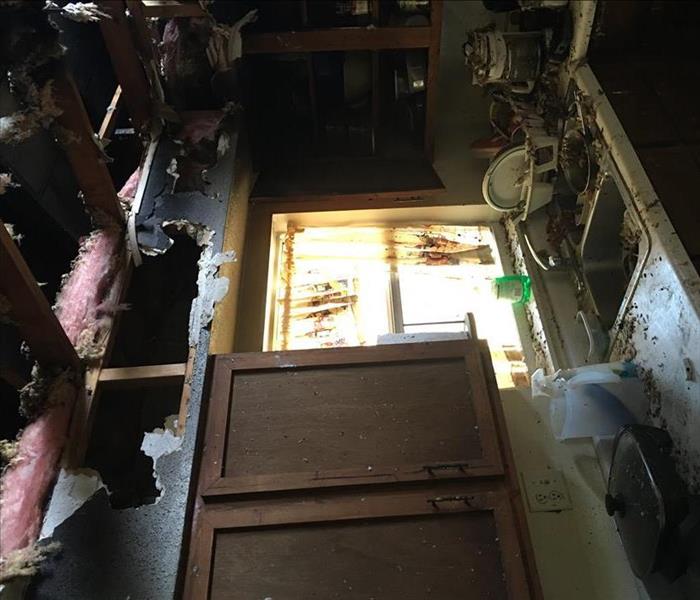 charred and damaged ceiling and kitchen cabinets, a mess